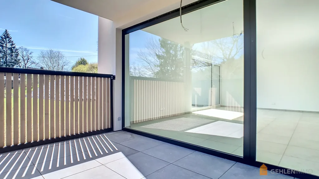 Baie vitrée donnant sur la terrasse d'un appartement neuf de la R2sidence Les Abords du Lac à Robertville