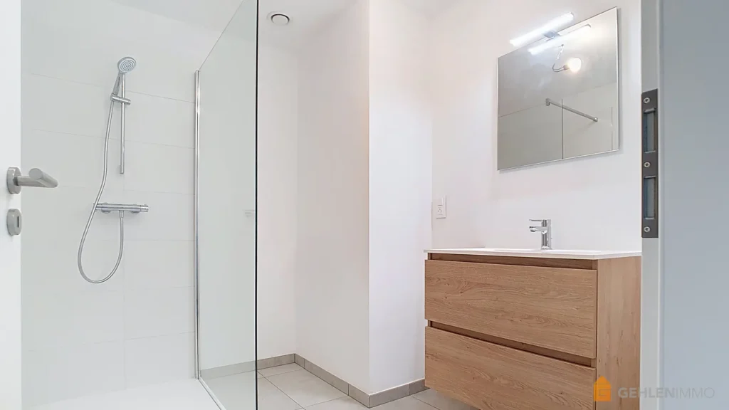 Salle de bain avec douche à l'italienne dans un appartement neuf